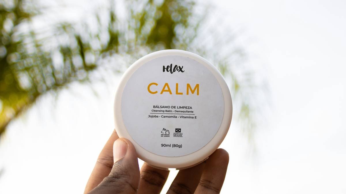 Woman applying calming protective balm to irritated cheeks during winter