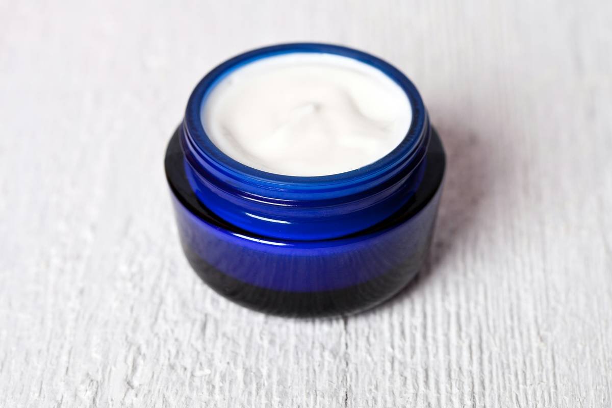 Close-up of moisturizing balm with vitamin E jar showing natural texture and ingredient label highlighting mixed tocopherols