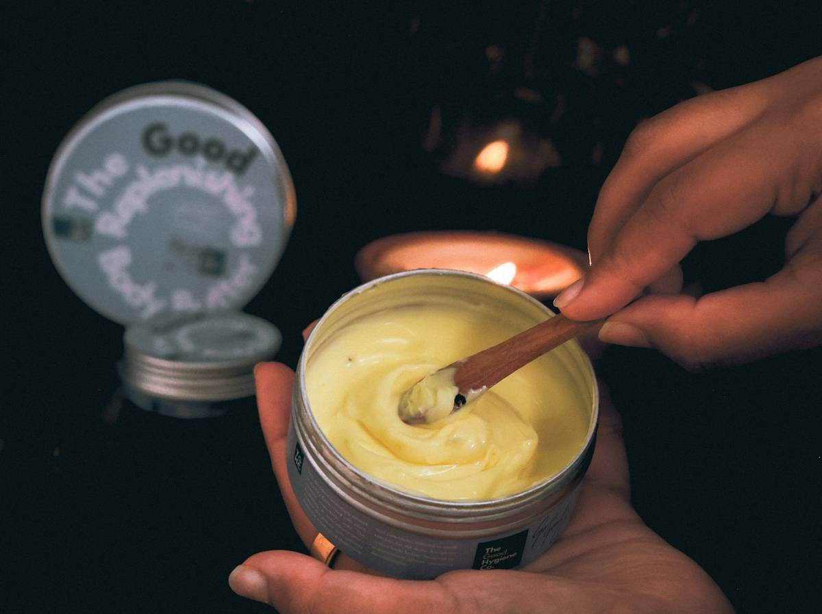 woman applying moisturizing balm for hands to cracked knuckles with visible relief