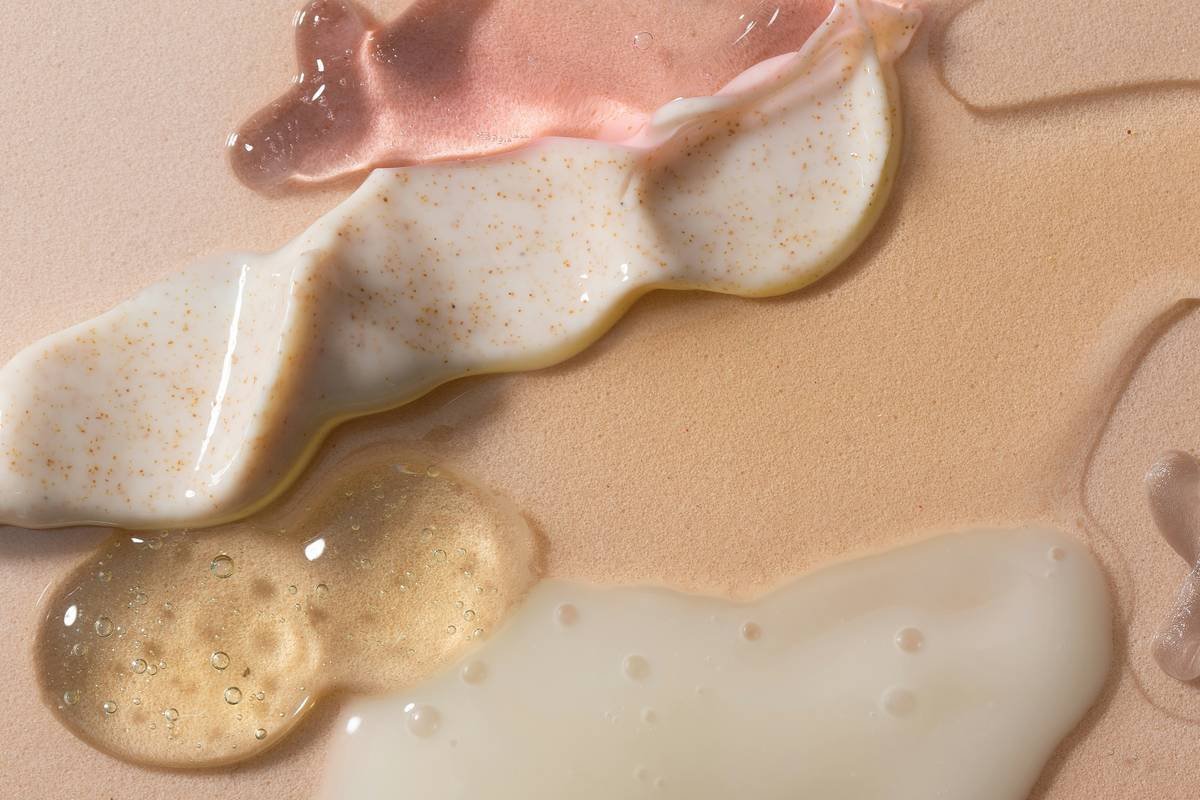 Woman applying moisturizing balm for skin repair to her cheeks in natural light